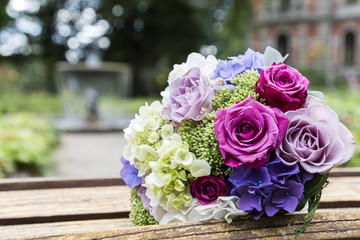 Wedding bouquet of roses on bench in park