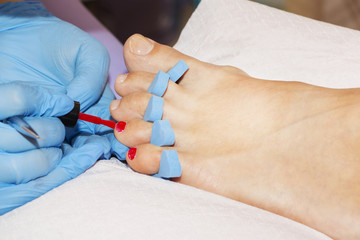 Woman feet receiving pedicure. Close up concept.