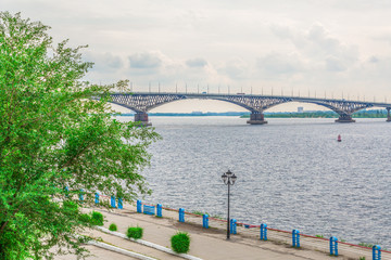 Fototapeta na wymiar Road bridge over the Volga river between Saratov and Engels, Russia. Cloudy summer day. City quay.