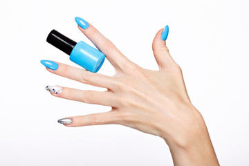 Beautiful summer blue manicure on female hand with nail polish. Close-up. Picture taken in the studio