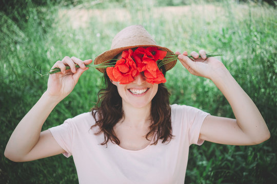 Woman holding a bouquet of red poppies in spring