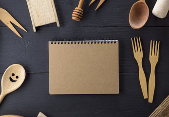 open notebook with blank pages in the middle of wooden kitchen items
