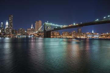 Colourful city lights at night from Brooklyn Bridge in New York City
