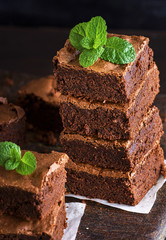 Baked square pieces of chocolate brownie pie are stacked