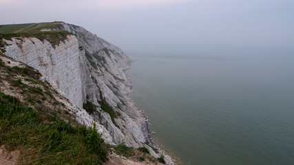 Foggy Seven Sisters Cliffs coast landscape in England at sunset