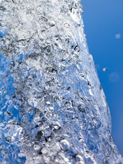 Splashing water with drops on the sky background