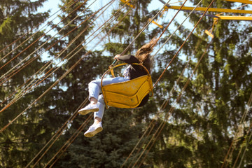 A girl is riding a carousel in the park