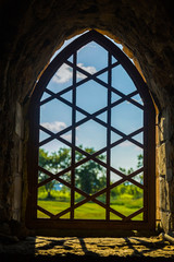 Old window with metal grille on an abandoned building