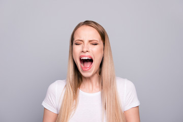 Closeup portrait of angry woman screaming loud close eyes isolated on gray background
