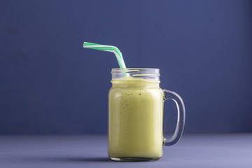 Fresh smoothies from avocado, banana, mango and honey on gray background. Closeup. Concept healthy eating