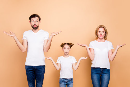 Portrait Of Young Family Bieng Confused, Bearded Father, Blonde Mother And Their Little Daughter Wearing Jeans And T-shirts, Showing Uncertain Gesture With Their Hands