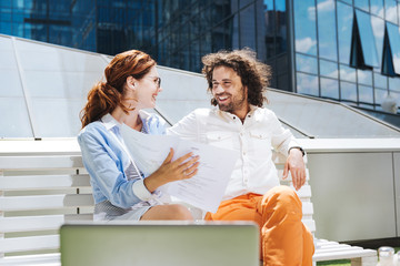 Bearded man. Bearded curly man smiling broadly while talking to his beautiful woman sitting near him