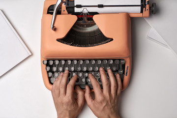 Hands printing on retro typewriter