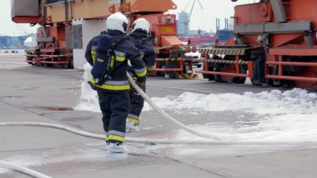firefighters using fire-extinguishing foam