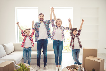 Ownership concept. Young happy smiling caucasian family wearing casual moving to new flat, standing...