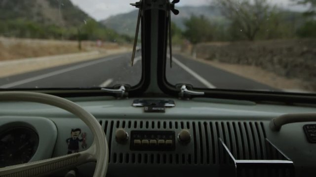 slow motion of oldtimer car driving through spanish landscape