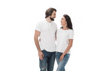 portrait of smiling couple hugging and looking at each other isolated on white