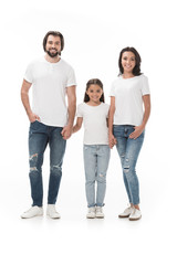 Fototapeta premium smiling family in white shirts holding hands and looking at camera isolated on white
