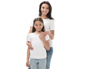 portrait of happy mother and daughter looking at camera isolated on white