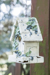 Ornate birdhouse hanging on a chain