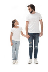 happy father and daughter holding hands and looking at each other isolated on white