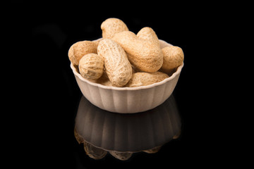 Fried peanut in shell in a bowl on a black background