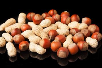 Hazelnut and roasted peanut in shell on a black background