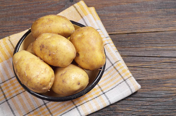 Bowl with raw potatoes