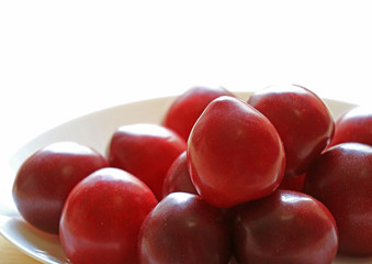 Plate of Fresh Gulf Ruby Plum Fruits in the Morning Light, Selective Focus and Blurred Background