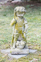 Sculpture of boy holding fish and fishing rod in his hand