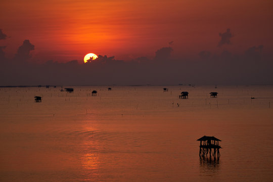 Fototapeta scenic of sunrise skyline and seascape fisherman cottages