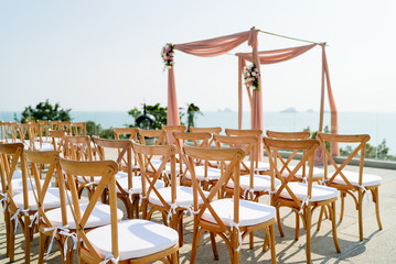 Wedding venue setting on the hill with wooden folding lawn chairs with panoramic ocean background view