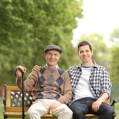 Elderly man and a young guy sitting on a bench