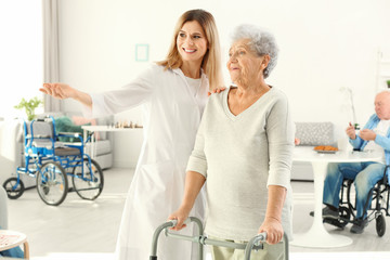 Senior woman with walkers and nurse at care home