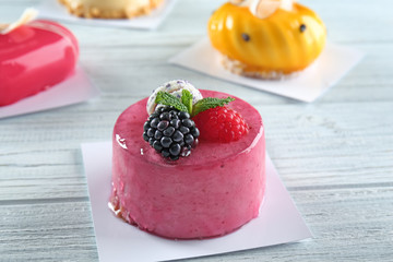 Tasty berry mousse cake on wooden background