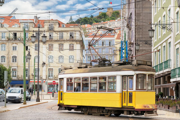 Naklejka na ściany i meble Vintage Yellow tram in the city center of Lisbon in a beautiful summer day, Lisbon, Portugal.
