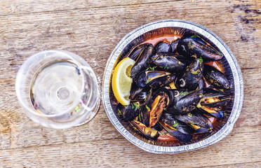Delicious mussels in aluminium tray with lemon