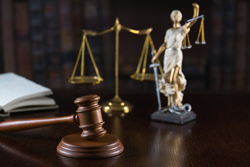 Lawyers office room with the scales of justice, hammer and old law books in the background