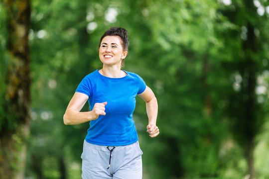Smiling Senior woman running in park. Heathy life style concept. Copyspace.
