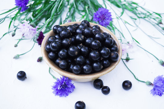 Berries of a tasty, large black currant on a table in a small plate