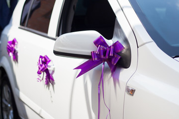 Purple wedding bows on the car door