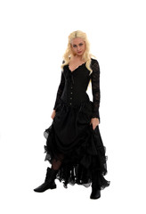 full length portrait of blonde girl wearing corset and long black gown. isolated on white studio...