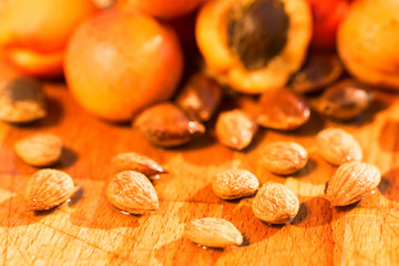 Fresh apricots and seeds on wooden surface