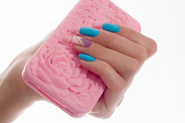 Female hands with blue manicure hold a pink  cover.