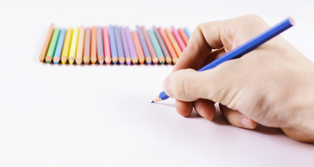 closeup.woman's hand draws a blue pencil on a white sheet of pap