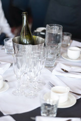 champagne bottle and glasses of champagne on the dining table, preparing for the celebrations. Selective focus on the bottle of champagne
