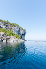 Obraz premium Bright clear aqua green water on Bruce Peninsula (Cave Point) with big limestone rocks