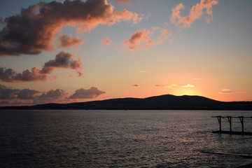 Sunset over the sea. The Sun sets behind the mountains