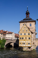 Fototapeta na wymiar Bamberg. Panoramic view of Old Town Hall of Bamberg (Altes Rathaus) with two bridges over the Regnitz river, Bavaria, Germany