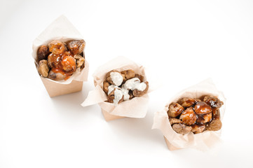 Top view of three isolated paper packs filled with tasty chestnuts